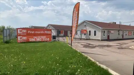 Bow flags and fence signs at Mini Mall Storage in Moncton.