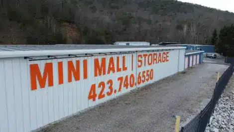 Large exterior wall sign reading Mini Mall storage with a phone number